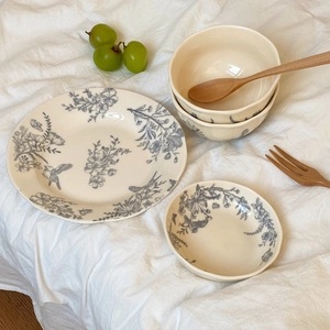 Detail of vintage French ceramic set with blue floral bird patterns and wavy edges