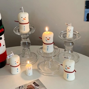 Detail view of snowman scented candles in various sizes with Merry Christmas flags
