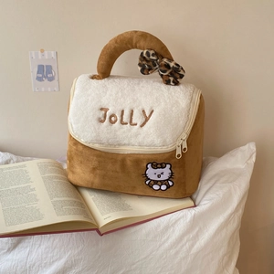 Detail of plush brown makeup bag with JOLLY embroidery and faux fur leopard bow handle