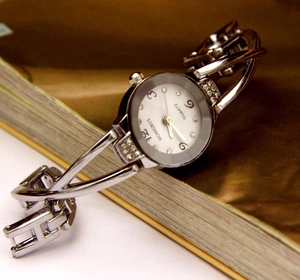 Dettaglio ravvicinato di un orologio a bracciale argento con lunetta di strass e quadrante bianco