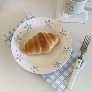 Ceramic starfish plate with golden croissant and matching fork for breakfast scene
