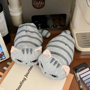 Dettaglio dell'astuccio a forma di gatto in peluche grigio su una scrivania accogliente