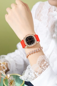 Close-up of luxury square quartz watch with red silicone strap and crystal bezel