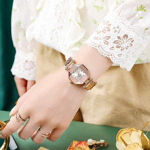Detail of rose gold octagonal watch with rhinestone markers and mesh steel strap