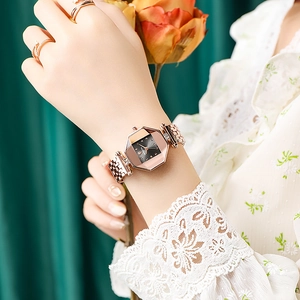 Elegant rose gold watch with octagonal case and matching rings on a female model