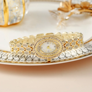 Dettaglio di orologio di lusso con strass e cinturino a forma di foglia su porcellana