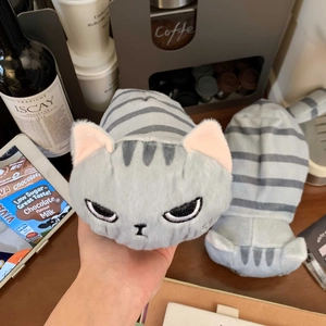 Dettaglio dell'astuccio a gatto in peluche a righe grigie con ricamo frontale e coda