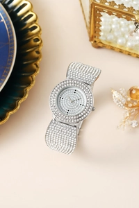 Macro shot of silver quartz watch with full crystal pavé on dial and band for women