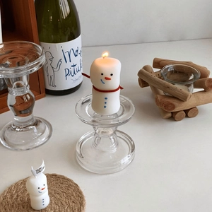 Cozy holiday scene featuring two snowman scented candles with festive Christmas decor