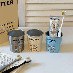 Detailed view of three stainless steel toothbrush mugs with cute cartoon dog patterns