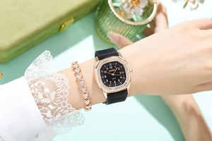 Detail of rose gold rhinestone square watch and matching heart bracelet on woman wrist