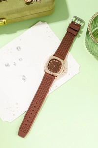 Detailed macro view of square rhinestone-encrusted rose gold case with brown dial