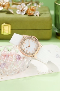 Detailed macro of rhinestone bezel square quartz watch and white silicone strap