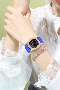 Detail of luxury rose gold square watch with rhinestones and blue silicone strap