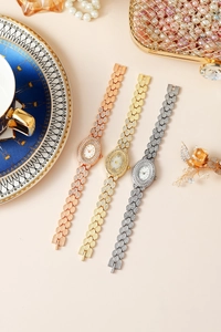 Dettaglio di orologi di lusso con strass in oro rosa, oro e argento su uno sfondo elegante