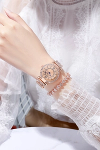 Dettaglio dell'orologio di lusso in oro rosa con strass e bracciale a cuore da donna