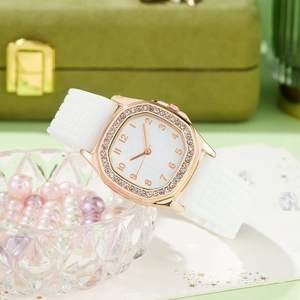 Close-up of rose gold rhinestone bezel watch with white textured silicone strap