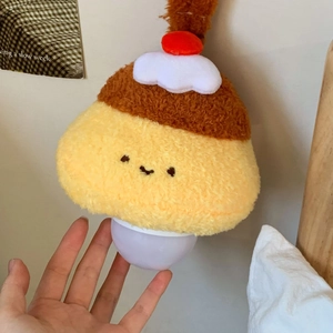Close-up of cute pudding-shaped plush night light with glowing base for bedroom decoration