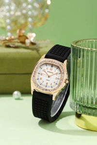 Macro detail of gold octagonal rhinestone bezel and black silicone strap on women's watch