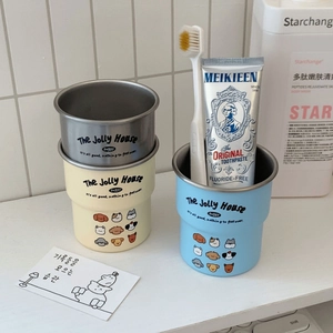 Close-up of cute cartoon dog patterns on stainless steel toothbrush cups in bathroom
