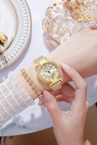 Primo piano di un orologio al quarzo dorato di lusso e bracciale in strass coordinato