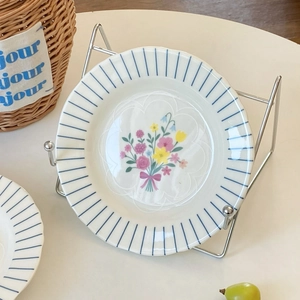 Floral ceramic bowl with blue stripes and butterfly ribbon detail on a display stand