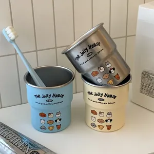 Three stainless steel cartoon dog cups for couple set with toothbrush on white bathroom tile