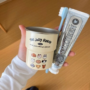 Close-up of a cartoon dog pattern mug with stainless steel interior and blue toothbrush
