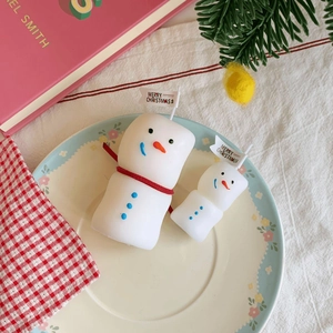 Macro detail of snowman candles with Merry Christmas flags in a holiday festive setting