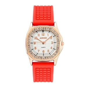 Macro view of rose gold octagonal bezel with crystals and textured red silicone strap