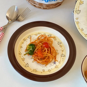 Ceramic plate with star and bird motifs holding pasta with broccoli and tomatoes