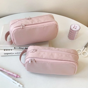 Top view of pink minimalist dual-layer pencil case with stationery on desk