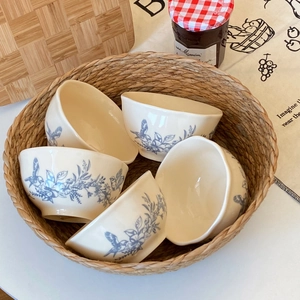 Detail of five ceramic bowls featuring vintage blue floral and bird patterns in French style