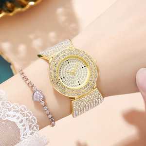 Close-up of gold-plated rhinestone watch and heart-shaped crystal bracelet on wrist