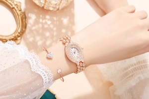 Dettaglio dell'orologio di lusso in oro rosa con strass e bracciale con cuore al polso