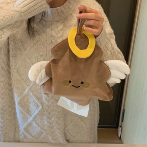 Detail of funny poop emoji plush tissue box holder with wings and halo hanging loop