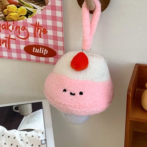 Detailed view of the strawberry cake plush night light hanging on a wooden wall hook