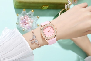 Close-up of pink quartz watch with rhinestone square case and matching bow bracelet