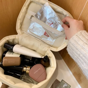 Innenansicht der großen beigen Kosmetiktasche mit Netztaschen und Kosmetika
