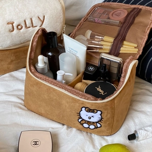 Macro detail of plush makeup pouch interior showing mesh organizer and partitions