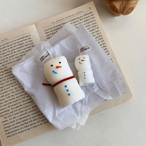 Detailed view of two snowman scented candles with red scarves and Christmas flags