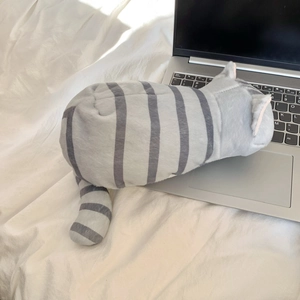 Dettaglio macro dell'astuccio a gatto grigio in peluche con texture morbida e striature