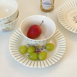 Detailed view of floral ceramic bowls with blue radial stripes and delicate petal patterns