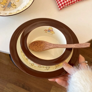 Close-up of Little Prince ceramic dinnerware set including a bowl, plate and wooden spoon