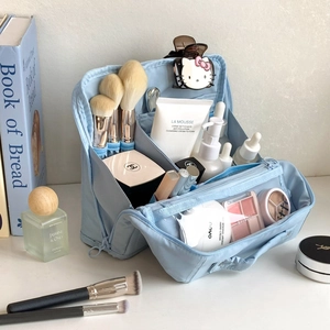 Detail of light blue waterproof makeup bag showing multi-layer interior and brush slots