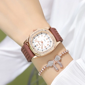 Detail of square rose gold watch with silicone strap and rhinestone bow bracelet