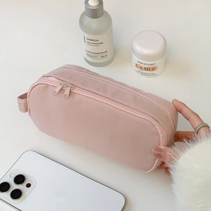 Detail of pink double-zipper travel makeup bag with handle and large capacity storage