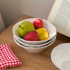 Detailed texture of white rock-patterned ceramic bowls with fresh fruits in a home setting