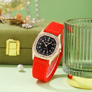 Detail of square rose gold watch with rhinestones and a textured red silicone strap