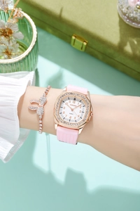 Close-up of a women's square rhinestone watch with pink silicone strap and bow bracelet